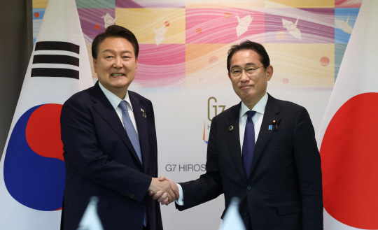 G7 정상회의 참관국 자격으로 일본을 방문 중인 윤석열 대통령이 21일 히로시마 평화기념공원 국제회의장에서 열린 한일 정상회담에서 기시다 후미오 일본 총리와 악수하고 있다. 연합뉴스
